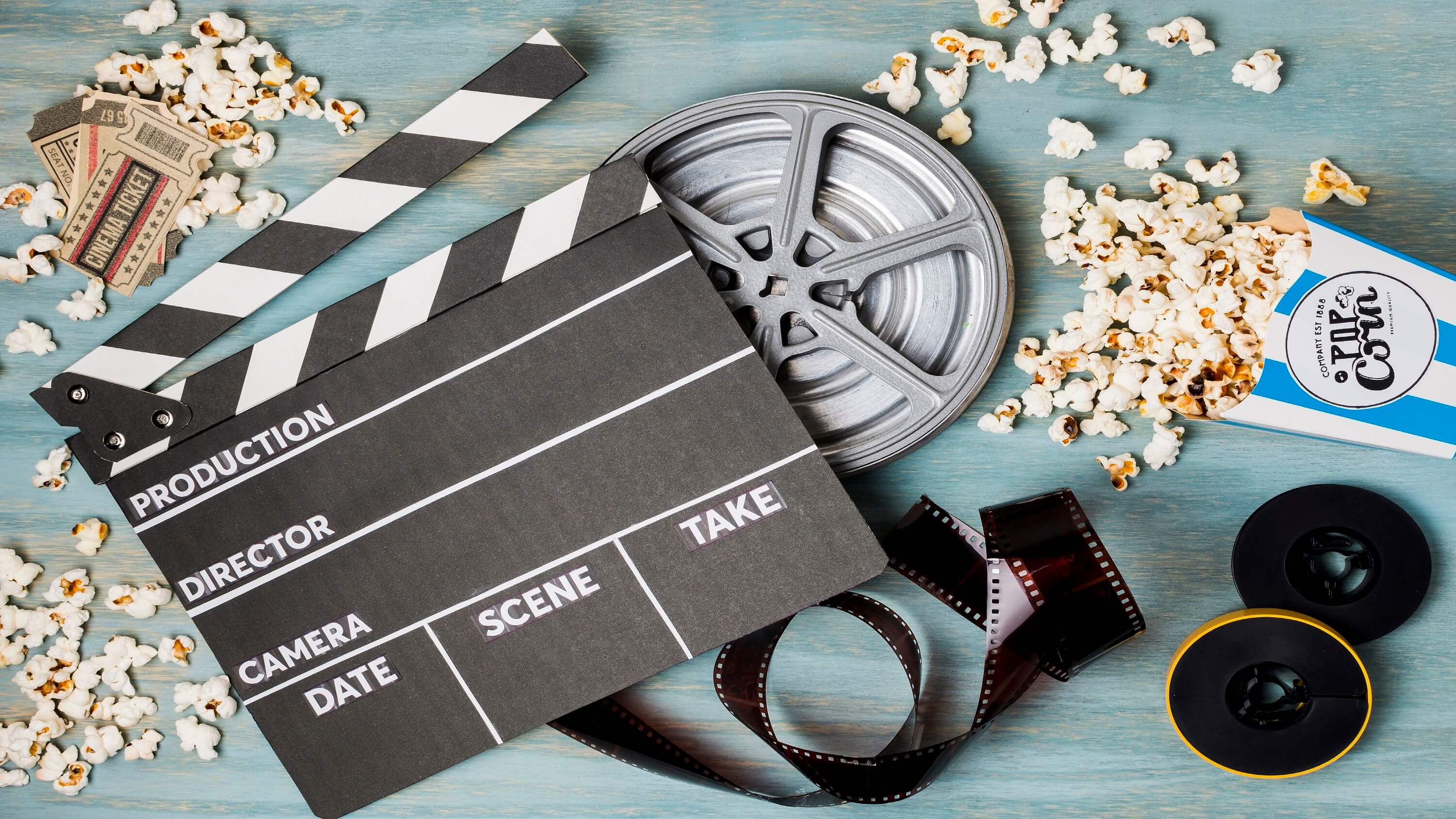 media industry clapperboard-popcorn-film-stripe-cinema-tickets-wooden-desk (1)